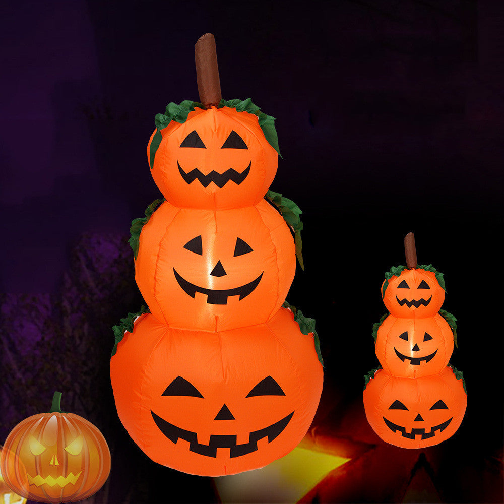 Citrouille gonflable Halloween à trois étages avec visages sculptés, éclairée dans un décor sombre